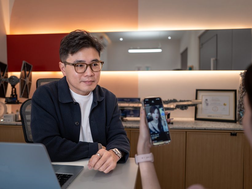 Dr Ong Jin Khang seated at his desk reviewing notes on a laptop, photographed in natural light at The Retreat Clinic consulting room
