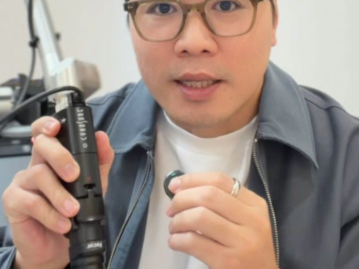 Dr Ong Jin Khang seated and holding a device mid-explanation in a clinical setting, no patient in frame